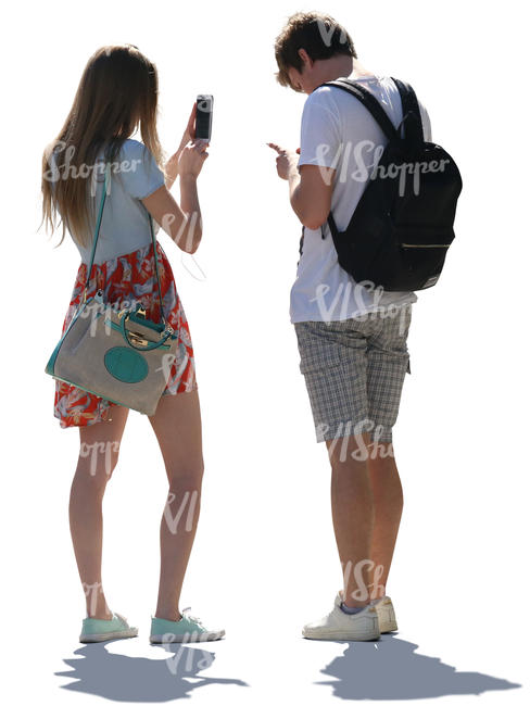 backlit young man and woman standing and checking their phones 