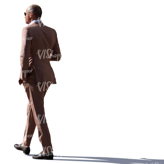 backlit man in a brown suit walking