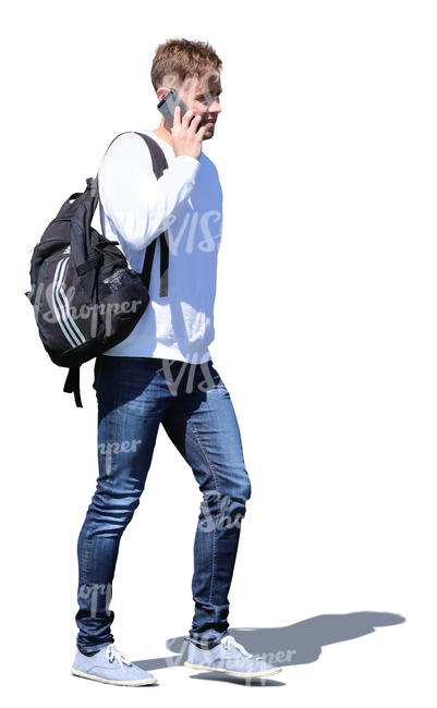 young man with a backpack walking and talking on the phone