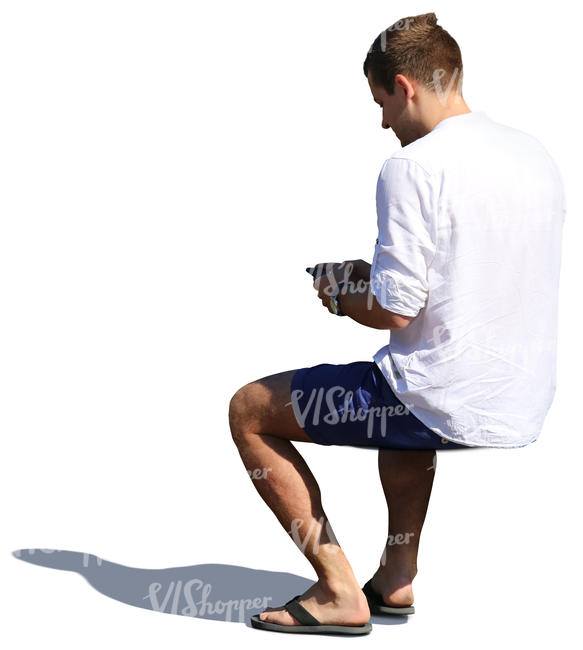 man sitting and looking at his phone