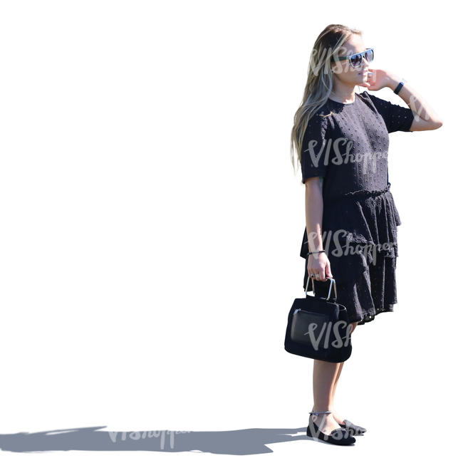 sidelit woman in a black summerdress standing