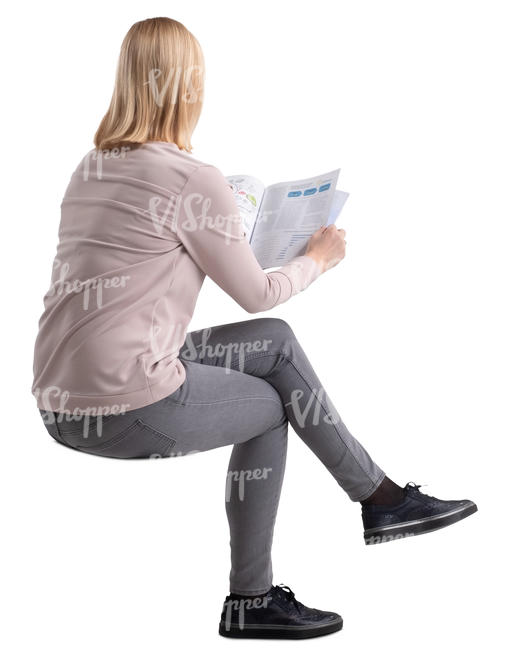 woman sitting at a table and reading a magazine