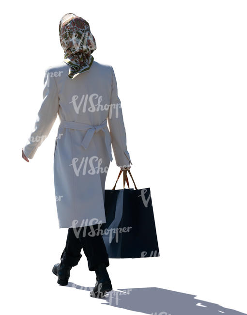 backlit woman with a headscarf walking