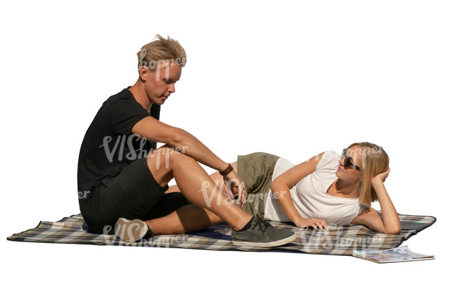 man and woman sitting on a picnic blanket and talking