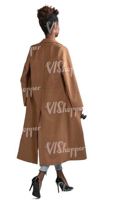 black woman in a brown overcoat walking