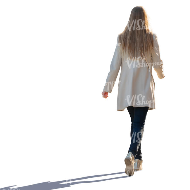 backlit woman in a light overcoat walking
