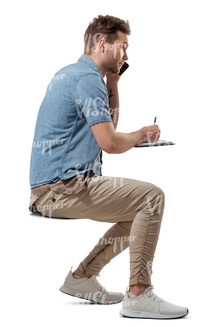 man sitting at a table and writing