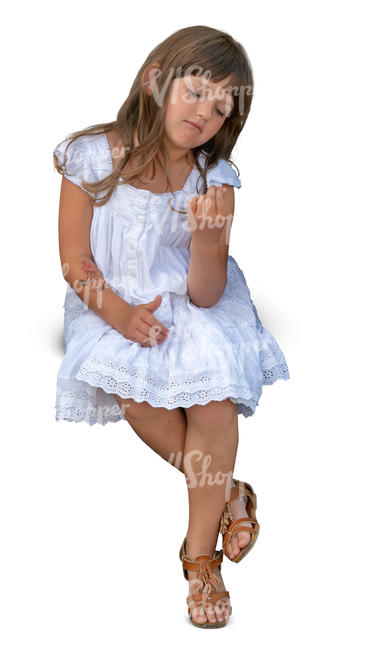 little girl in a white dress sitting
