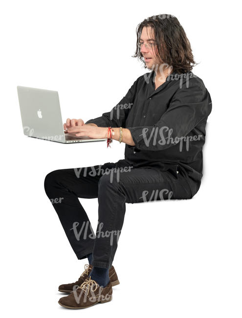 man sitting at a desk and working with laptop