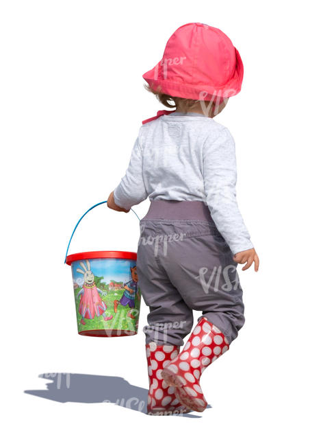 little girl with a toy bucket walking