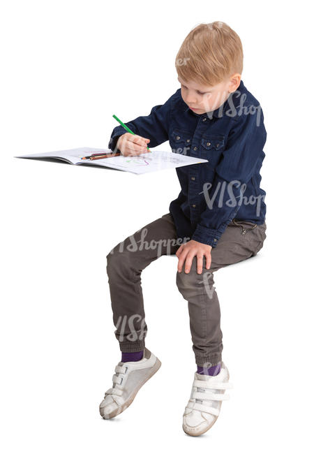 boy sitting behind the desk and drawing