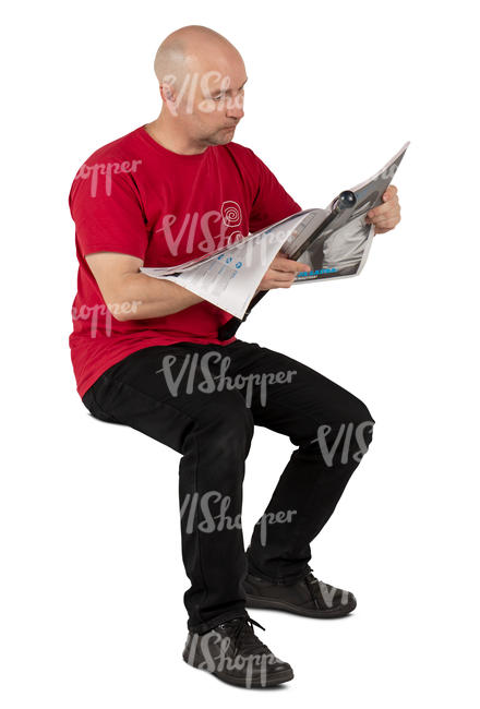 man in a red shirt sitting and reading a newspaper