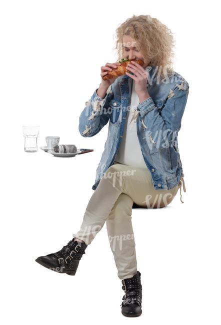 woman sittng in a cafe and eating a sandwich