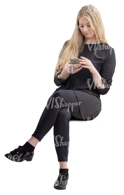 woman in black sitting and looking at her phone