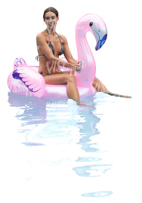 woman floating on a pink flamingo in a pool