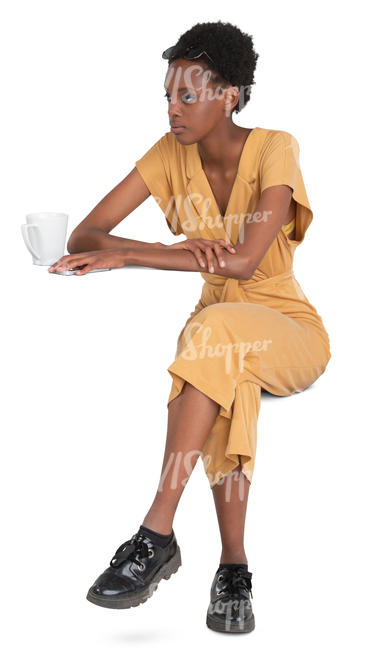 black woman in a yellow jumpsuit sitting in a cafe