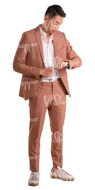asian man in pink suit standing and looking at his watch