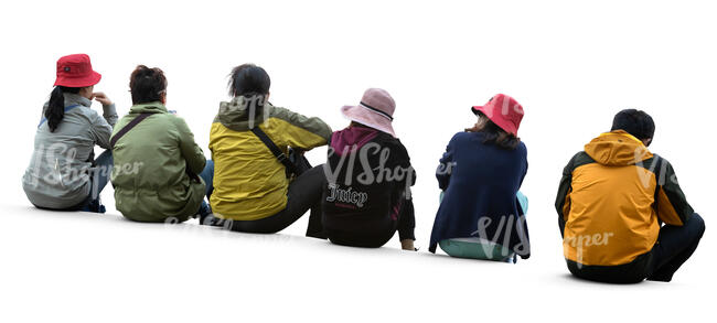 group of six people sitting on a sidewalk