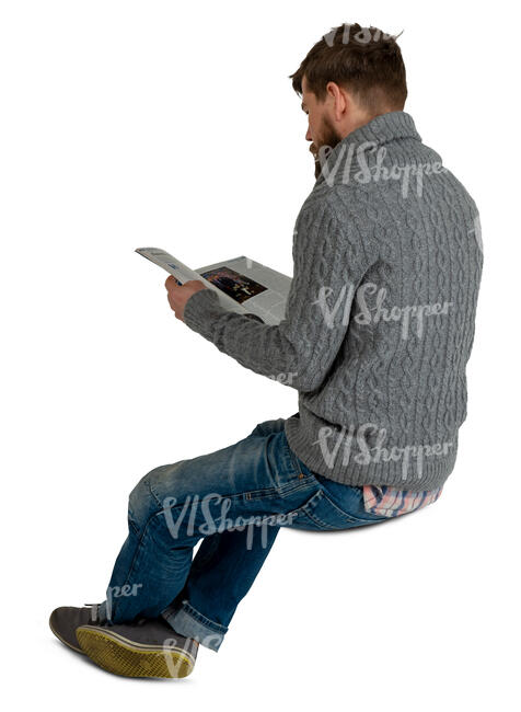 man sitting and reading a magazine
