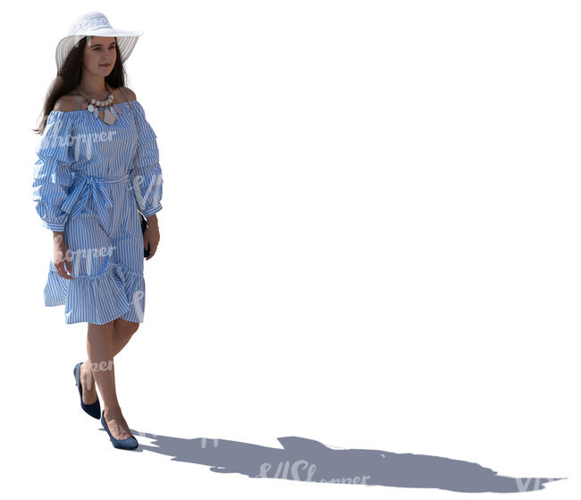 backlit woman with a summer hat walking