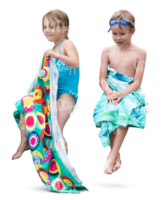 two kids with towels sitting after swimming