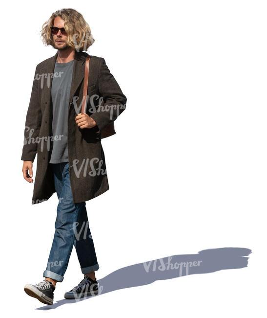 man with curly hair and light overcoat walking