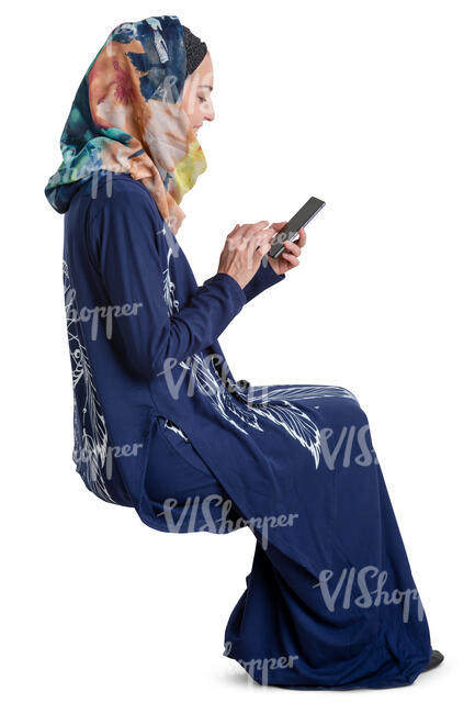 muslim woman sitting and looking at her phone