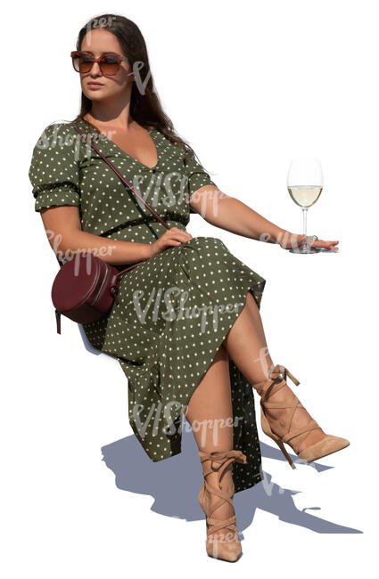 woman sitting in an outdoor cafe and drinking white wine