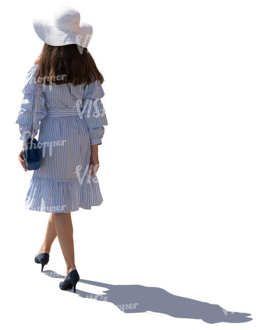 backlit image of a woman in summer dress walking