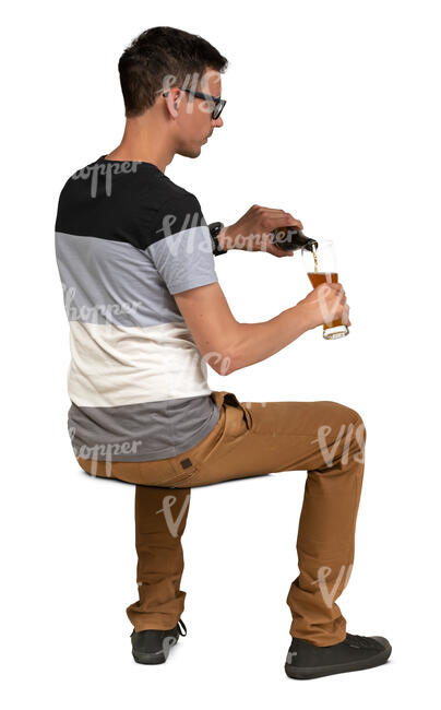 man sitting at a cafe table and pouring himself a drink