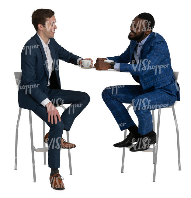 two men in suits sitting in a cafe and talking