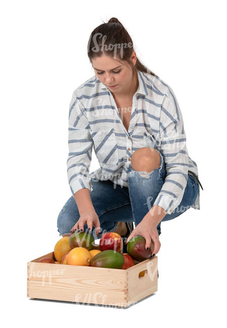 woman squatting and putting fruits in a box