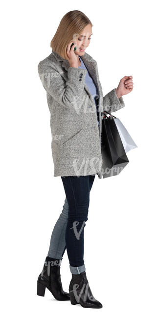 woman with shopping bags standing and talking on a phone