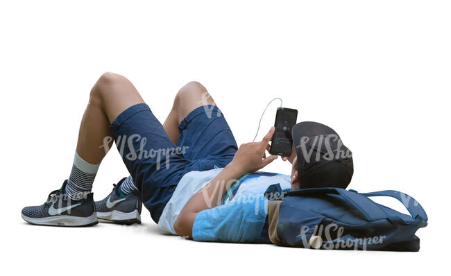 man lying on the ground and listening to music