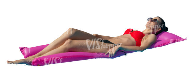 woman sunbathing on a swim mattress in the pool