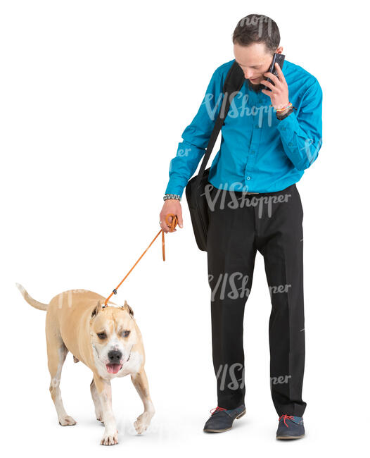 man with a dog standing and talking on a phone
