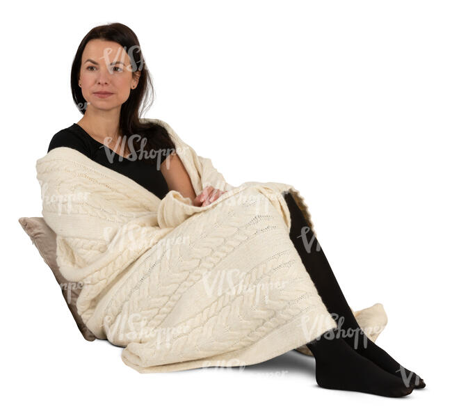 woman wrapped in a blanket sitting on a sofa