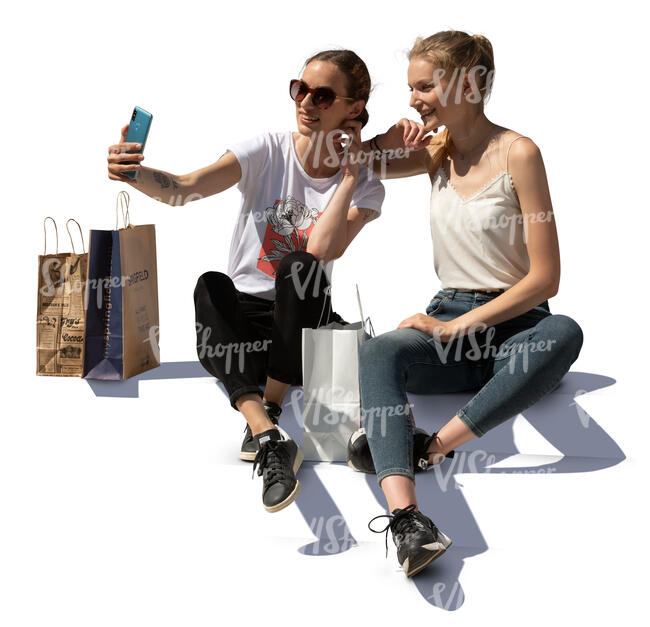 two young women sitting on stairs and taking a selfie