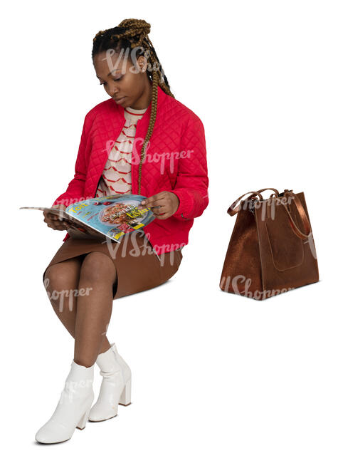 woman in a red jacket sitting and reading a magazine