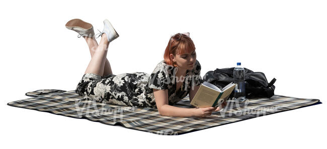 cut out young woman lying on the ground and reading a book