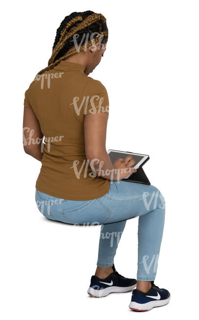 cut out black woman sitting and looking smth at her ipad
