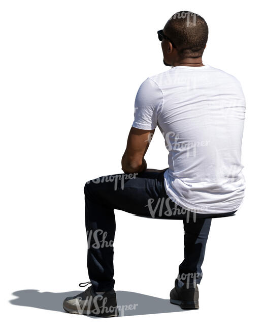 cut out man sitting outside in the sun seen from back angle