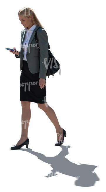 cut out backlit businesswoman with a phone in her hand walking