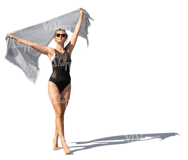 cut out woman in a black swimsuit holding a light towel walking on the beach