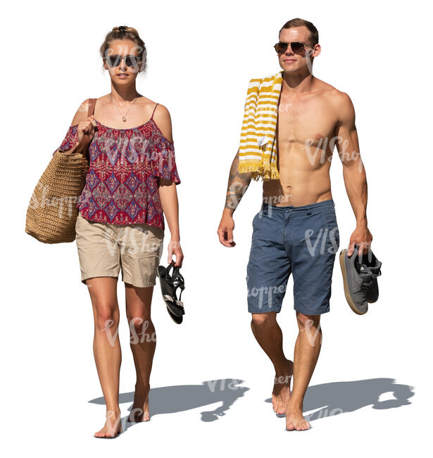 man and woman walking barefoot on the beach