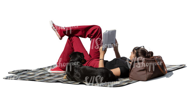 cut out young woman lying on the picnic blanket and reading a book