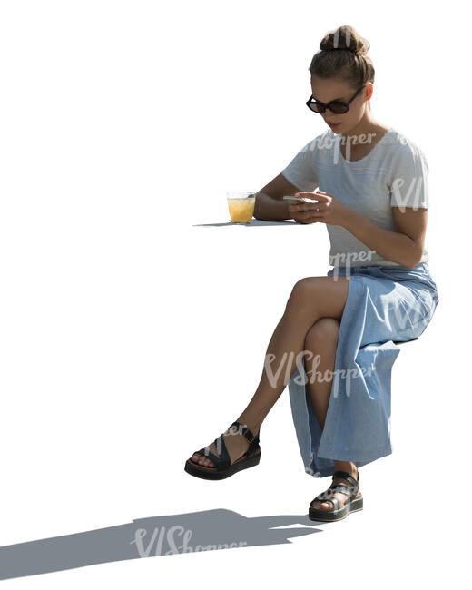cut out backlit woman with a phone in her hand sitting in a cafe