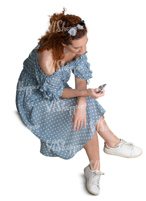 cut out woman in blue dotted dress sitting seen from above