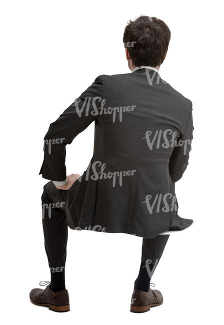 cut out man in a black suit sitting seen from behind