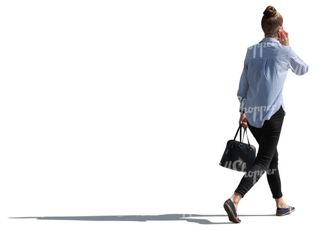 backlit woman walking and talking on the phone